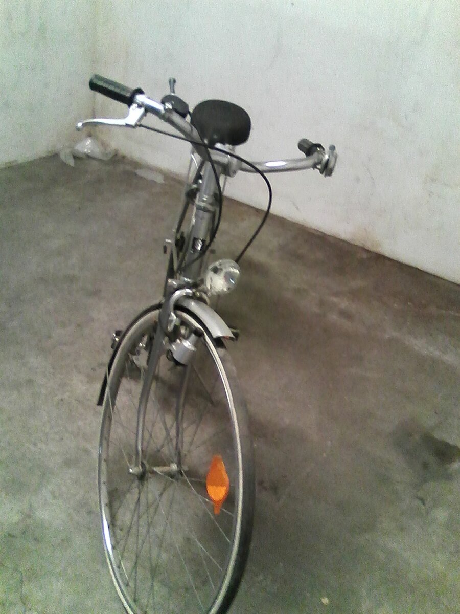 Bicicleta clássica prateada de quadro de barra, farol e dínamo