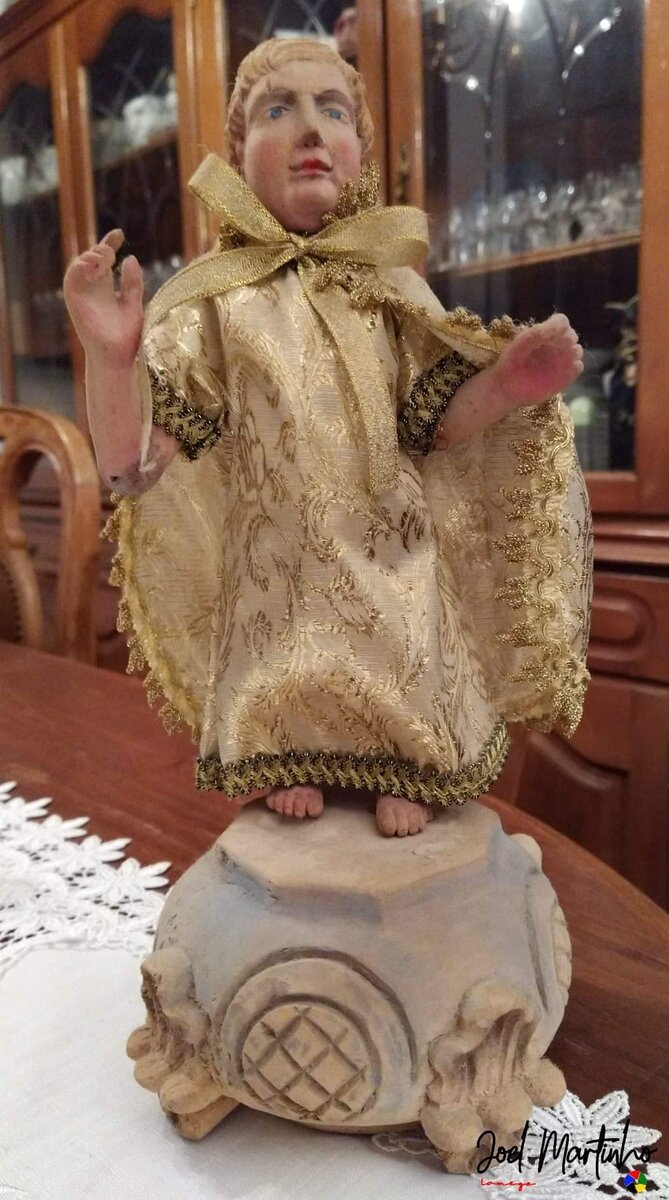 Menino Jesus antigo em pé, manto de brocado dourado, base em pedra lavrada