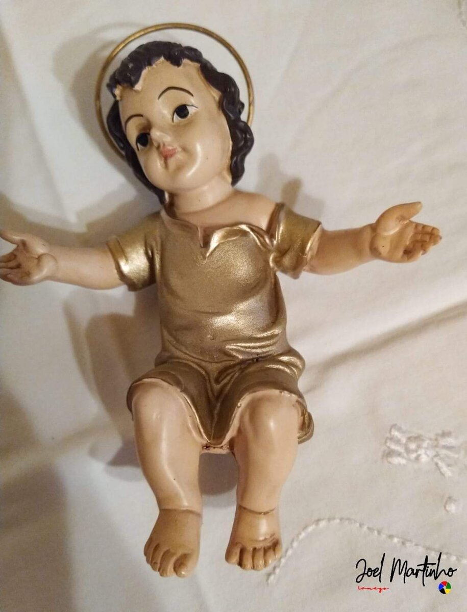 Menino Jesus sentado com auréola metálica e túnica dourada