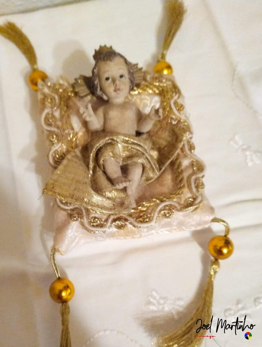 Menino Jesus com coroa sobre almofada com borlas e contas douradas