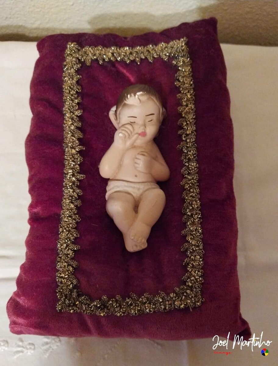 Menino Jesus a dormir sobre coxim de veludo bordeaux com galão dourado