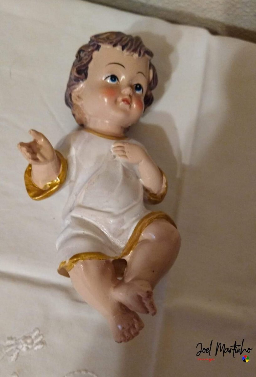 Menino Jesus sentado com túnica branca e dourada