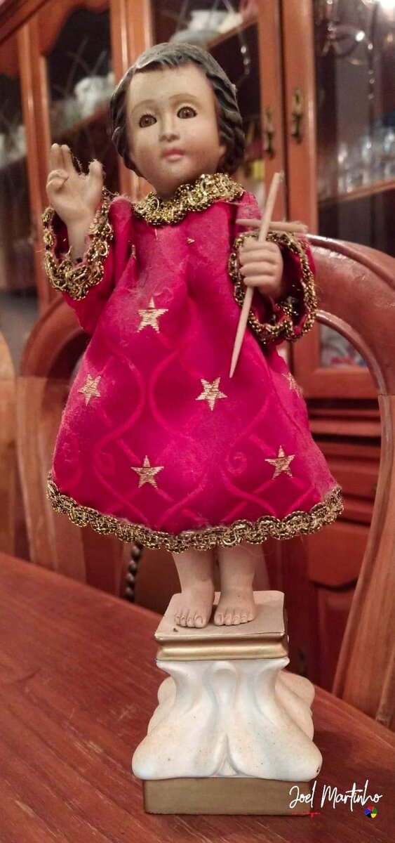 Menino Jesus em pé com túnica cor-de-rosa bordada a estrelas douradas