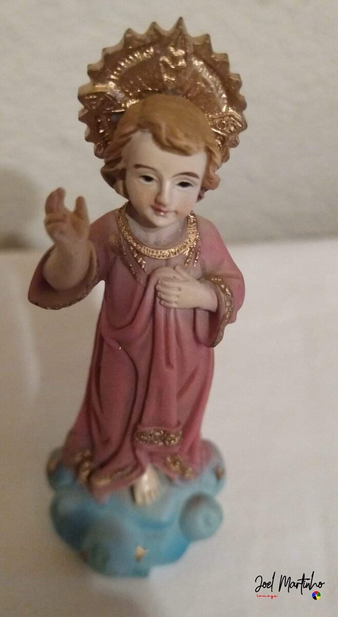 Menino Jesus em pé, túnica rosa e resplendor dourado, base azul