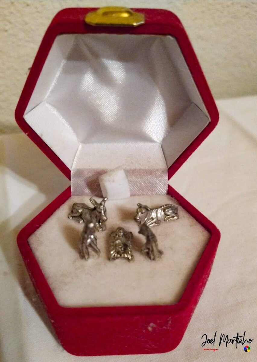 Presépio em miniatura com figuras de metal prateado, em caixa de veludo vermelho